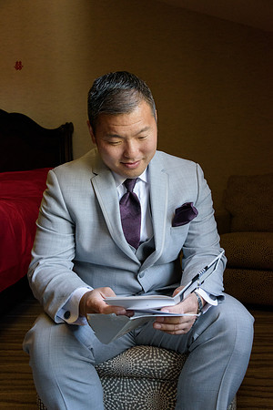 Asian American groom opening letter from his bride at The Heritage Hotel Wedding in Southbury, CT