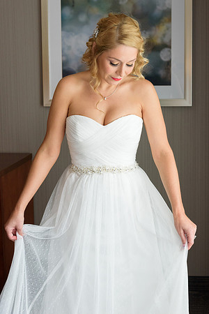 Bride admiring her dress, getting ready wedding photos at hotel