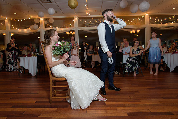 Groom removes the garter during wedding reception