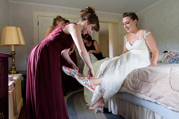 Maid of honor helping her sister bride get ready Goshen Connecticut rustic farm wedding