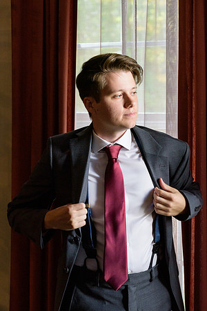 Groomsmen putting on suit getting ready shots home in Torrington, Connecticut window lighting